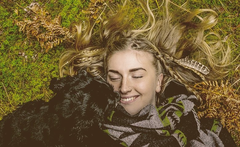 You’ll be able to fight off depression and anxiety. girl laying down on the grass with a dog