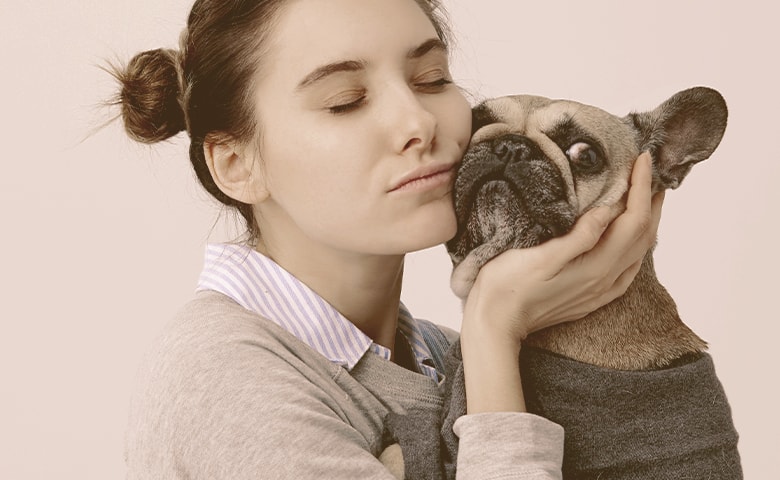 girl pressing her cheek to French bulldog