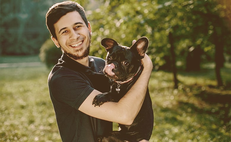 man holding a French bulldog